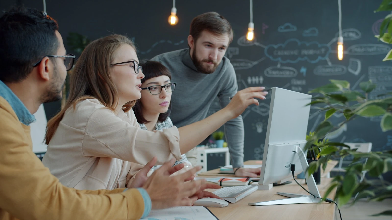 A team collaborating around a computer